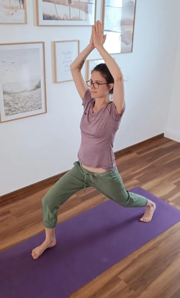 Hebamme Ursina in einer Yoga-Stellung auf der Matte