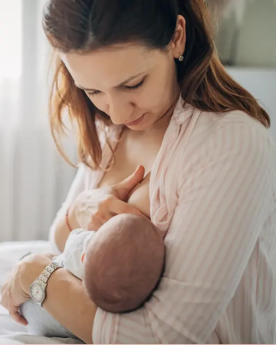 Mutter stillt ihr Baby und schaut liebevoll auf es herunter